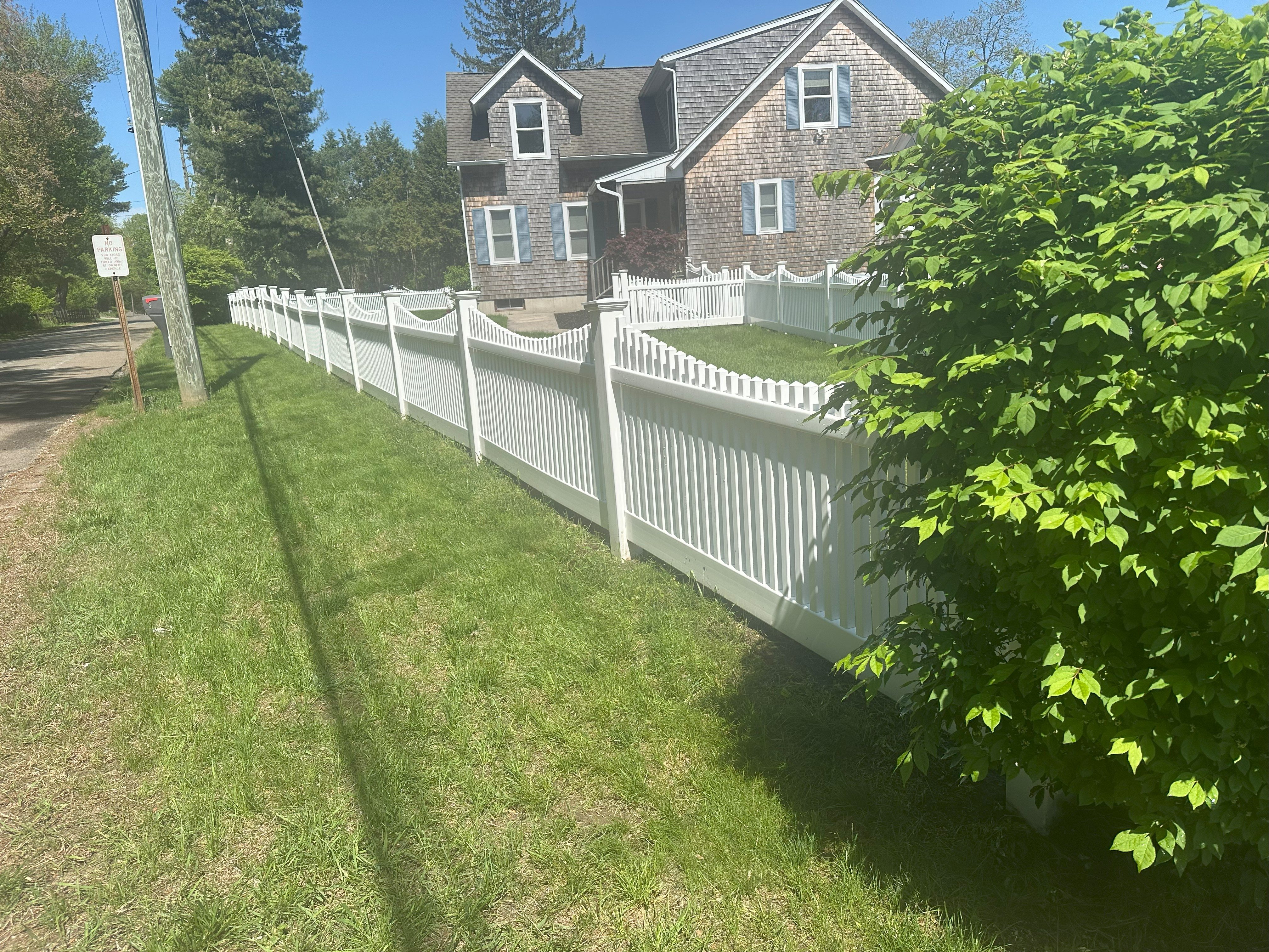 Fence after professional pressure washing Voluntown CT - clean and bright white